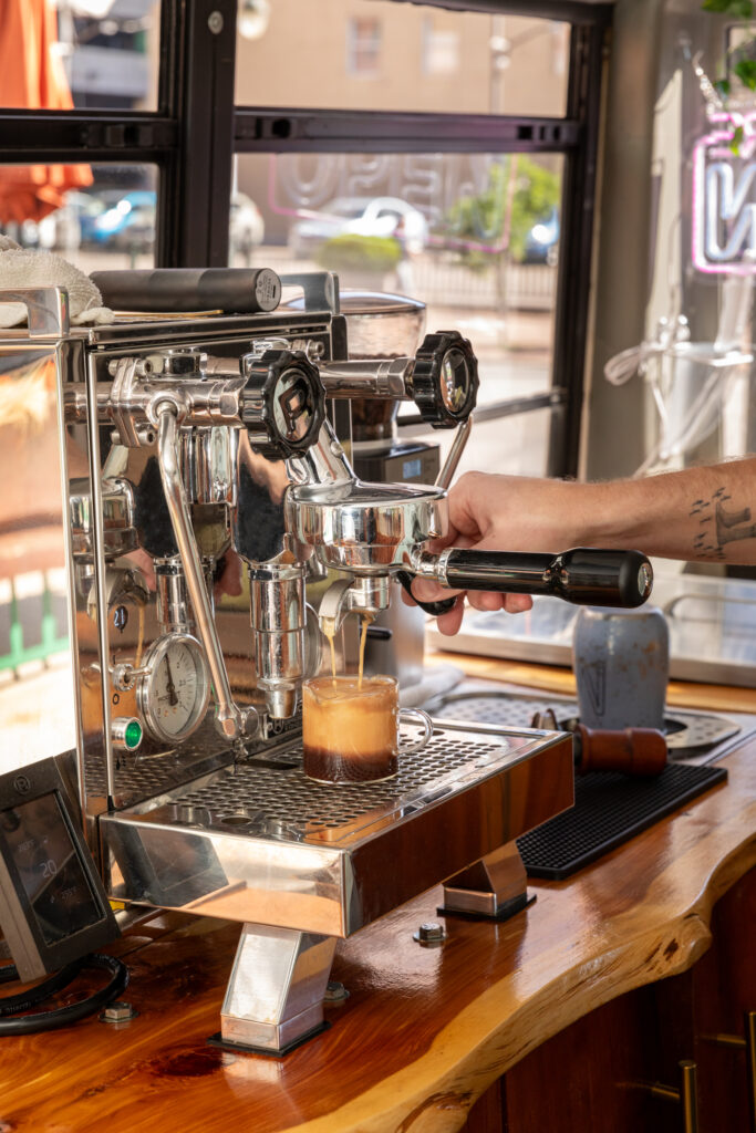 River Low handing coffee to customer outside Buspresso in Denver